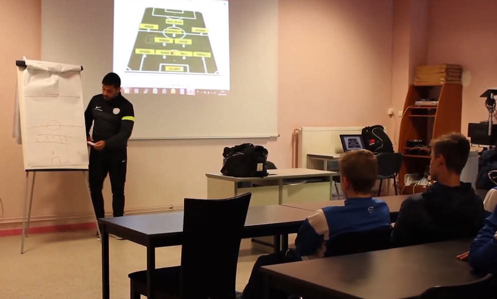 Mathieu Foïs pendant une causerie d'avant-match devant le schéma tactique